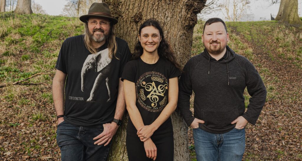 Tradify members standing in front of an old tree. Cedar is in the middle, Albert is on the left and Darragh is on the right. They look relaxed.